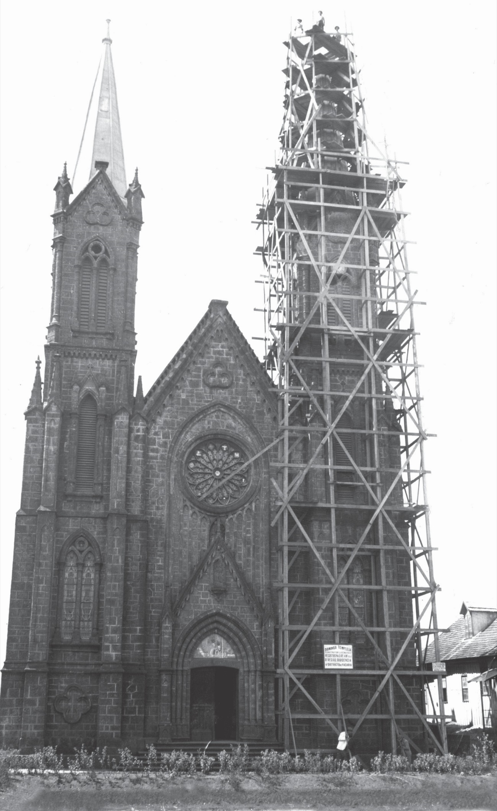 Fachada da Catedral com a torre da esquerda concluída e a torre da direita envolta em andaimes durante a construção.